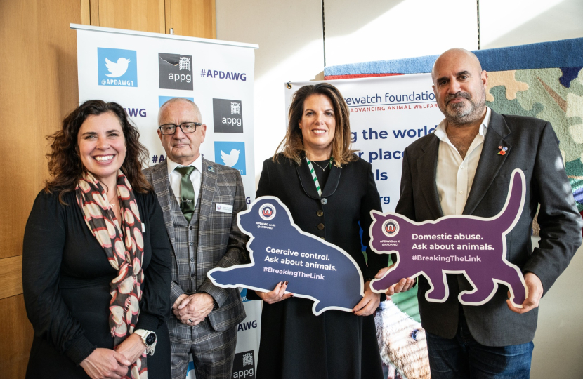 Caroline with representatives of the Naturewatch Foundation, holding a dog plaque, which reads "Coercive Control. Ask about animals. #BreakingTheLink"